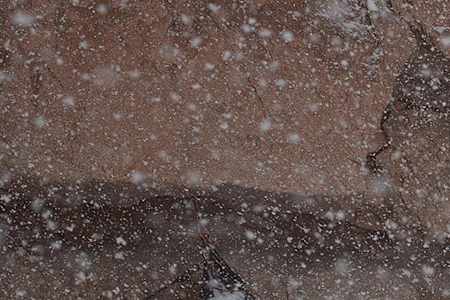 Climbers camp on a cliff face during a blizzard.