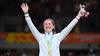 Laura Kenny with her arms aloft on the podium with her gold medal in Birmingham in 2022.