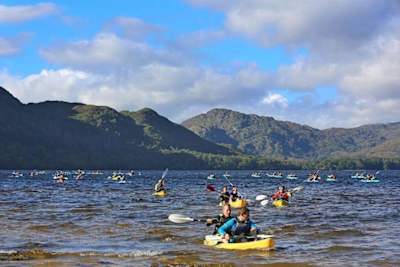 Varios participantes cruzan un lago durante una carrera de aventura en Irlanda.