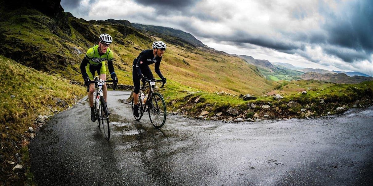 Two cyclists battle up a mountain.