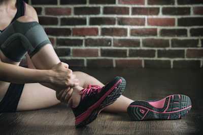 An athlete holds their injured ankle.