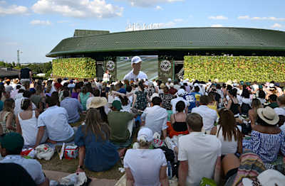 Spectators sit on The Hill as they watch the Men's Singles Final on the big screen at  Wimbledon 2025. 