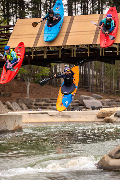 Evy Leibfarth in kayak, leaping off platform into water, surrounded by three others