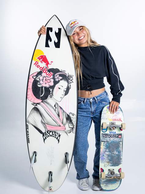 Sky Brown poses with her surf and skate boards.