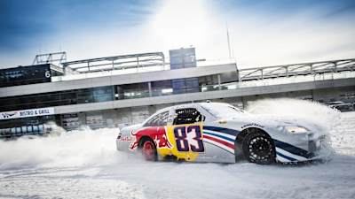 Ein NASCAR-Bolide driftet mit Spikes auf dem spiegelglatten Parcous