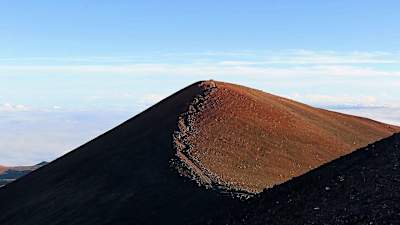 Varios senderistas alcanzan la cima del Mauna Kea.