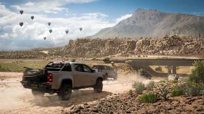 A pick-up races on a desert road in Forza Horizon 5.