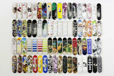 A skate shop board wall displays an array of skateboard deck styles
