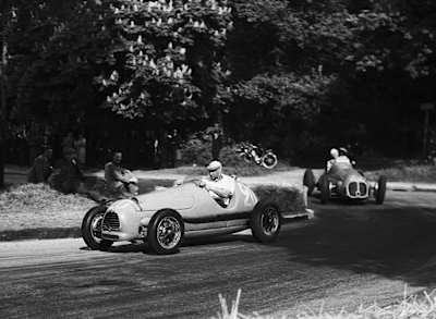 A photo of Juan Manuel Fangio and Giuseppe Nino Farina racing during the 1951 French Grand Prix.