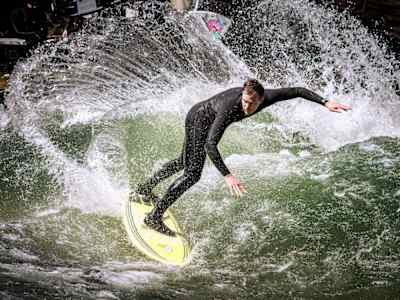 Eisbach-Legende Quirin Rohleder macht einen Backside Snap am Eisbach in München.