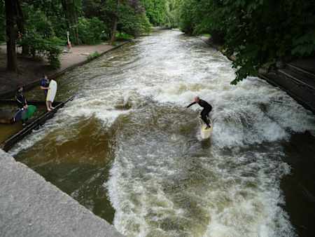 In München stehen Surfer zum Surfen der Eisbach-Welle bereit.