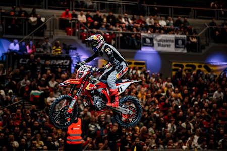 Tadeusz Błażusiak w akcji skaczący swoim motocyklem podczas rundy SuperEnduro w Budapeszcie, w tle tłumy kibiców na trybunach.