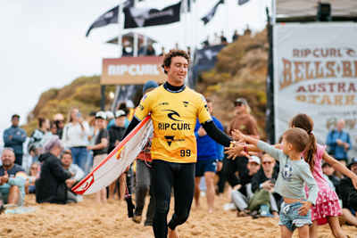 Griffin Colapinto runs through the crowd while surfing at the Rip Curl Pro Bells Beach