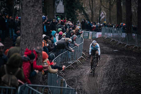 Wout van Aert rueda en Bélgica por una pista embarrada durante una carrera de ciclocross.