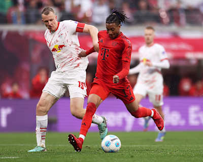 Michael Olise of Bayern Munich shoots whilst under pressure from Lukas Klostermann of RB Leipzig during the Bundesliga match between RB Leipzig and FC Bayern München.