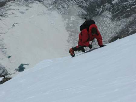 Mike Horn climbing up an ice-covered mountain