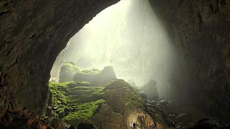 Silhouette of person stood in Hang Son Doong cave.
