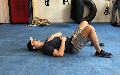 guy doing deep belly breathing in exercise room