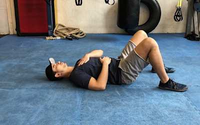 guy doing deep belly breathing in exercise room