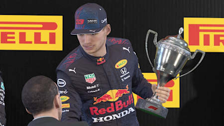 Screenshot von Max Verstappen mit Siegerpokal in F1 2021