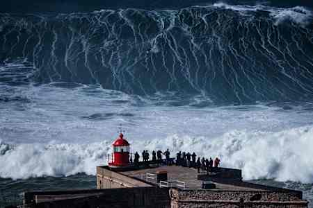 A surfer drops down the face of a huge wave at Nazare, Portugal.