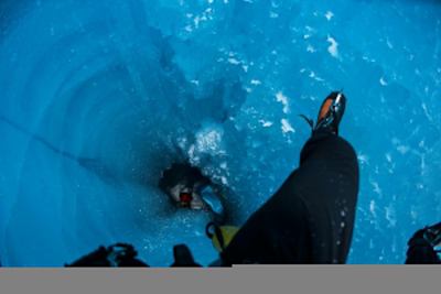 Photographer Christian Pondella follows climber Will Gadd down a moulin during Gadd's trip to explore the Greenland ice cap in 2018.