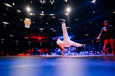 A B-Boy doing acrobatics on the dance floor at the Red Bull BC One Cypher Belgium 2019.