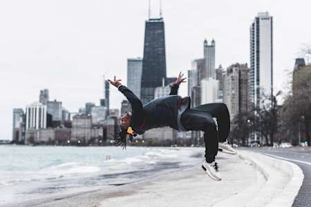 Neguin jumping backwards with the Chicago skyline in the background.