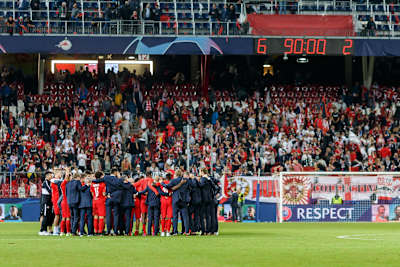 The coaching and playing staff celebrate on the Salzburg pitch