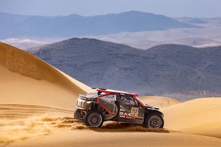 In the 2025 Dakar Rally, Cristina Gutiérrez and Pablo Moreno's Sandrider race car kicks up sand dunes in Saudi Arabia.