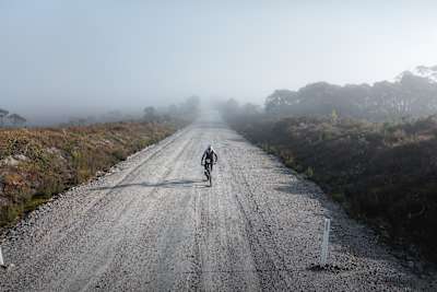 Payson McElveen cycles along a long stretch of gravel road in the film Crossing Tasmania.