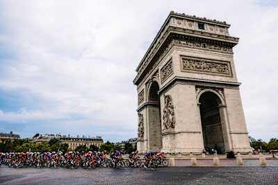 Tim Red Bull - BORA - hansgrohe prolazi 21. etapu u Parizu, utrkujući se pored Trijumfalne kapije tokom Tour de Francea 2025. godine