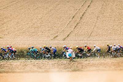 Florian Lipowitz from Team Red Bull - BORA - hansgrohe and the rest of the Tour de France peloton pass through cornfields outside Bolougne in 2025.