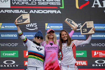 Valentina Höll, Tahnée Seagrave, and Mille Johnset celebrate on the podium at the UCI Mountain Bike World Cup in Pal Arinsal, Andorra, July 12, 2025.