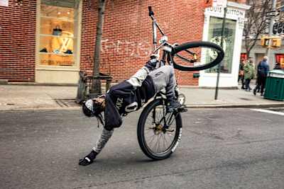 Obloxkz drags his hand along the ground while performing a wheelie.
