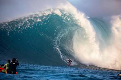 This image of Gomez dropping in on a 30-foot wave at Jaws on Maui in January 2021 hangs in her home.