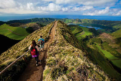 Hikers walk on a hiking route in the Sete Cidades area of Sao Miguel Island in the Azores.