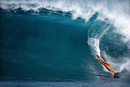 El surfista Mark Richard hace un giro mientras surfea en Hawái.