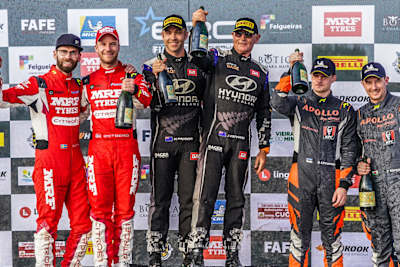 Paddon and co-driver Kennard celebrate on the Fafe podium