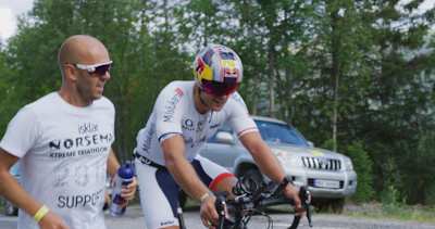 Ein Foto vom Norweger Andreas Mikkelsen auf dem Bike und einem Mitglied seiner Support-Crew.