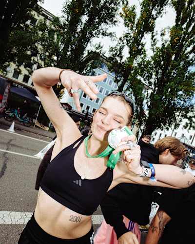Eine Salty Sports Club-Läuferin nach dem München Marathon mit Medaille.