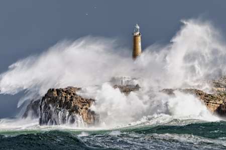 Der Leuchtturm von Isla Mouro in den Wellen in der Bucht von Santander, Spanien