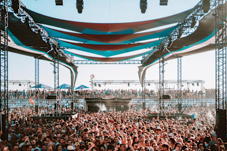 Vue impressionnante d’une foule compacte sous les structures ombragées du Delta festival, sur la plage du Prado à Marseille.