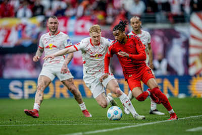 Michael Olise von Bayern München im Duell mit Nicolas Seiwald von RB Leipzig.