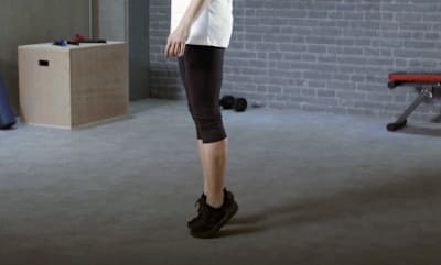 Le freerunner Hazal Nehir fait des élévations de mollets pendant l'entraînement à la stabilité.
