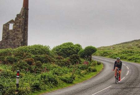 A cyclist descends a rural hill in the UK.