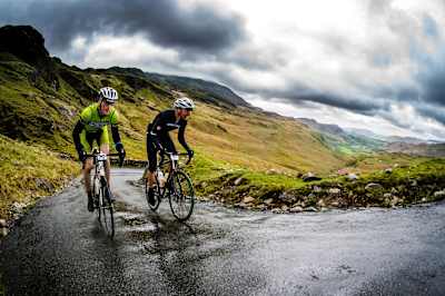 Two cyclists climbing up the ascent of the Hardknott pass.