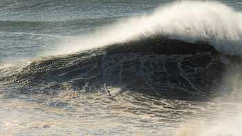 In 2022, Red Bull athlete Andrew Cotton rides a colossal wave at Nazaré, Portugal, showcasing explosive energy and fearless big wave surfing amid legendary Atlantic swells