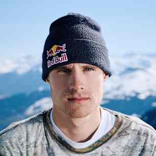 Snowboarder Gian Sutter poses for a Red Bull portrait in Laax, Switzerland, in April 2026, wearing a Red Bull beanie against a snowy mountain backdrop