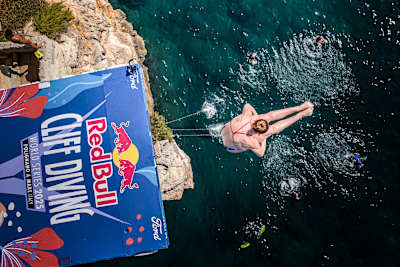 Molly Carlson tirándose por un acantilado, vista desde arriba.